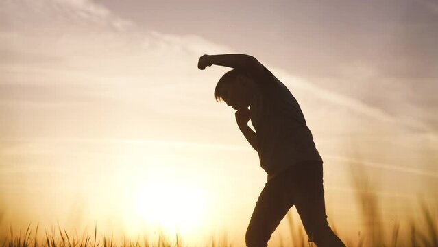 silhouette child kid boxer. boy a boxing with shadow exercising at sunset outdoor. kid dream. sport victory healthy lifestyle concept. child shadow boxing little sun champion boxer silhouette