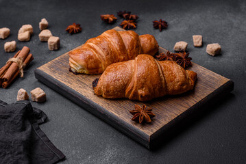 Fresh crisp chocolate croissants on wooden cutting board