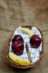 Wicker basket with fresh fruit on a rustic background.
