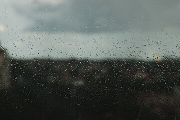 Glass with raindrops on the background of a thunderstorm. Raindrops on the background of the...