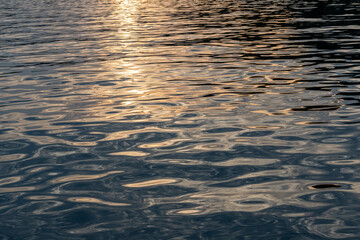 Sonnenuntergang spiegelt sich im welligen Meer