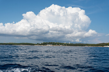 Kroatische Küstenlandschaft mit Meer im Vordergrund und Wolken am Himmel
