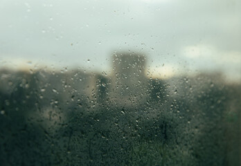 Glass with raindrops on the background of a thunderstorm. Raindrops on the background of the city.MOCKUP.Photo for design