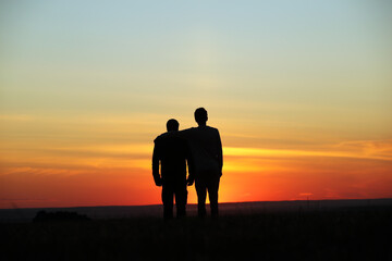Young adult son and father silhouette in the meadow on a sunset background. Pavel Kubarkov, i and my Father Alexander. Photo was taken in the evening 10 September 2022 year, MSK time in Russia. - 532830983