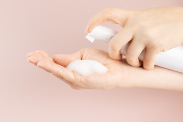 Cosmetics foam pump container, facewash dispenser in a woman's hand