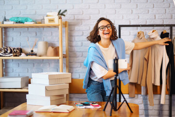 Young woman blogger talking with followers, live streaming recording new fashion video for vlog.  Оnline store, small business owner, seller, entrepreneur.