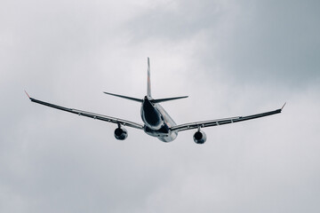 Passenger plane comes in for landing in cloudy weather.