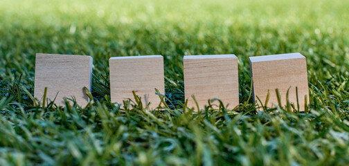 Four wooden cubes on a soccer field, mocap