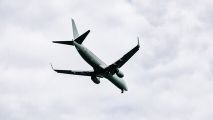 Passenger plane comes in for landing in cloudy weather.