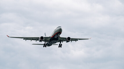 Passenger plane comes in for landing in cloudy weather.