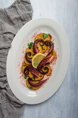 Octopus with potatoes and spices , on a light plate, top view, no people, homemade, close-up,