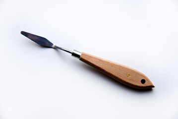 Palette knife No. 4 artistic iron with a wooden handle on a white background. An artist's paint tool.