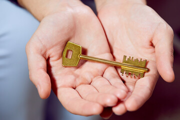 Fototapeta premium Close up of human hand holding golden key