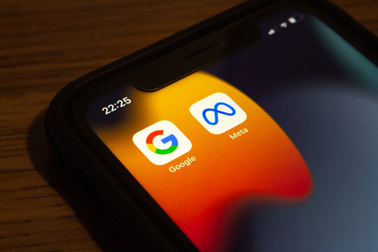 Vancouver, CANADA - Sep 23 2022 : Closeup icons of Google and Meta on an iPhone on wooden table. IT web based data collection from users, privacy law in cyberspace concept