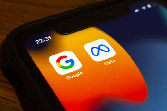 Vancouver, CANADA - Sep 23 2022 : Closeup icons of Google and Meta on an iPhone on wooden table. IT web based data collection from users, privacy law in cyberspace concept