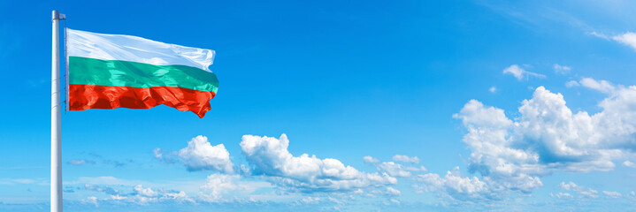 Bulgaria flag waving on a blue sky in beautiful clouds - Horizontal banner