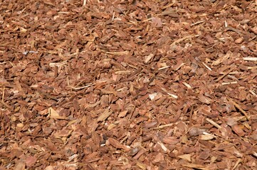 Red brown wood chips in the sun background 