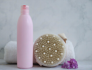 Fototapeta na wymiar Shampoo, towel, massage brush on a colored background