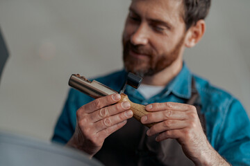 Business owner inhaling aroma of coffee in own manufacturing of roasted coffee beans