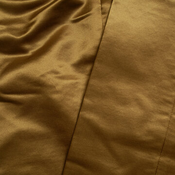 Close-up Of The Seam Of Rich Smooth Silky Gold Pants