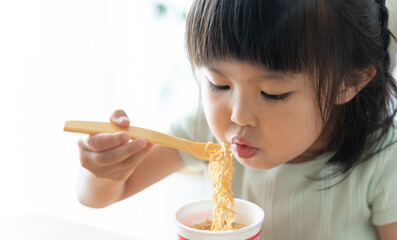 カップラーメンを食べる4歳の子供（食事・お菓子・育児・子育て）