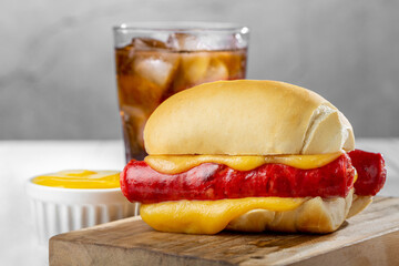Cheese and sausage sandwich with soda glass.
