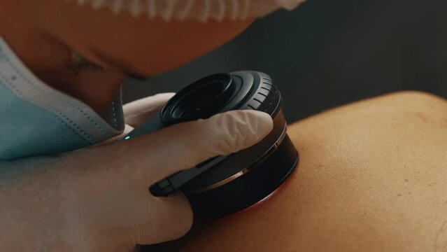 A dermatologist looks at a patient's skin.