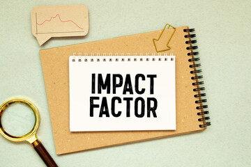 IMPACT FACTOR text written on sticky with pencil and glasses