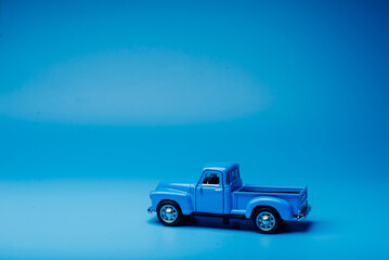 Fototapeta na wymiar Toy blue pickup truck on a blue background