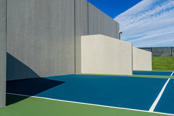 Example of an outside American Handball courts with concrete wall, located at a park or school.
