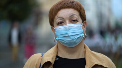 Sad red-haired middle-aged woman in wears a medical mask on the street to prevent the spread of the virus, coronavirus, infected by respiratory - 532854133