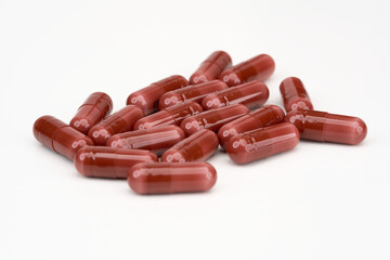 red capsule pills in a pile isolated on white background 