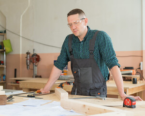 Portrait of a handsome male carpenter in the workshop.