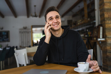 one man use mobile phone while sit at the table at restaurant