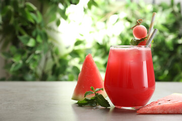 Delicious fresh watermelon drink on grey table. Space for text