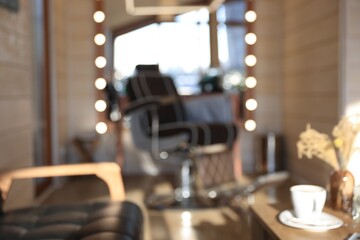 Blurred view of stylish barbershop interior with hairdresser workplace