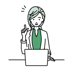 デスクで座ってPCを開いて何かひらめいたジャケットの女性