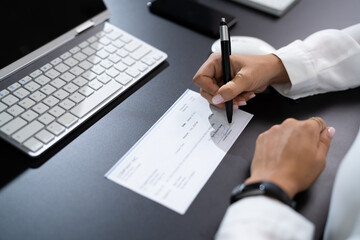 Woman Signing Bank Check