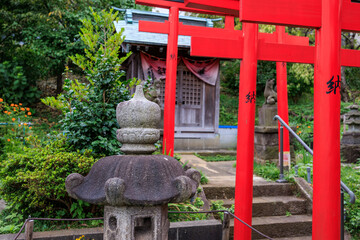稲荷神社に奉納された朱色の鳥居と石灯籠