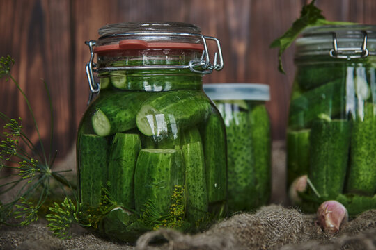 Preservations, conservation. Salted, pickled cucumbers in a jar on an old wooden table.