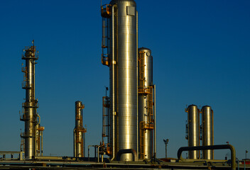 Gleaming refinery towers in the late afternoon sun.