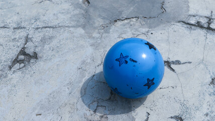 Blue ball with star pattern isolated on the concrete soccer field