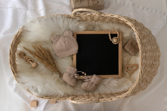 Letter Board Baby Announcement With Basket. Baby Clothing Mock Up . Space For Design . Pregnancy Announcement Background With Blurred . Selective Focus