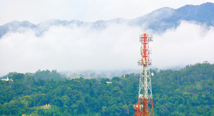 Mobile phone tower against the mystery background of evening fog or rain clouds at the mountains.  - Powered by Adobe