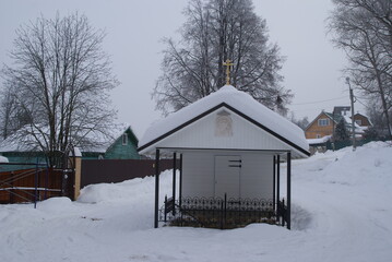 Font with holy water in deep snow on the slope of the valley of the river Puddle in Maloyaroslavets