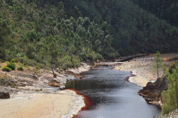 Landscape of reddish river with polluted water