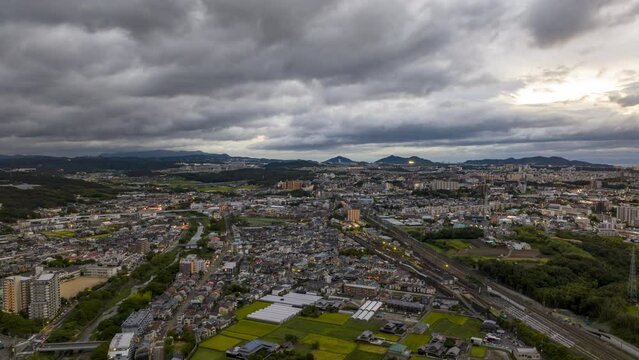 Hyperlapse: Fast moving storm clouds over sprawling town at dawn