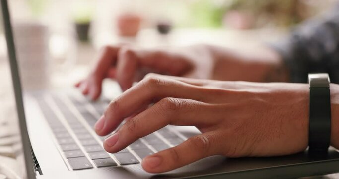 Journalist student typing a report on a laptop from home and zoom in of the hands of a male freshman studying and writing a college project in his house. Man working on a online proposal or essay