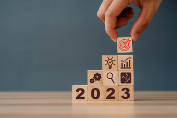 2023 Business development to success and growing growth concept. Preparation for happy new year ,new life, new business, plan, goals, strategy concept. Hand flips wooden cubes with 2023.