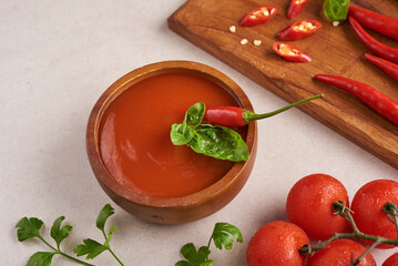 red hot chilli sauce. tomato ketchup, chilli sauce, puree with chili pepper, tomatoes and garlic. on wooden cutting board on stone background. top view.